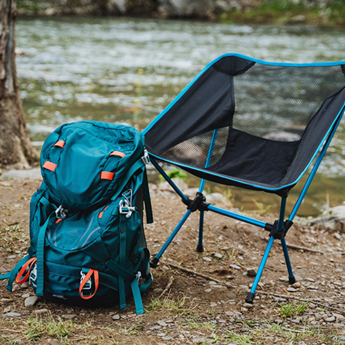 backpack and camp chair by a river