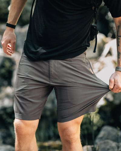 man wearing shorts pulling the stretchy fabric